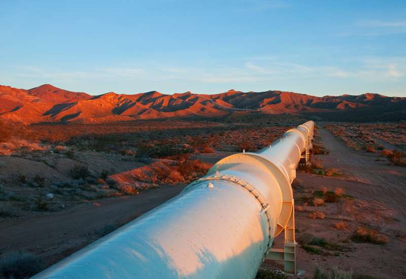 Pipeline leads through dry hilly landscape at sunset rosen group